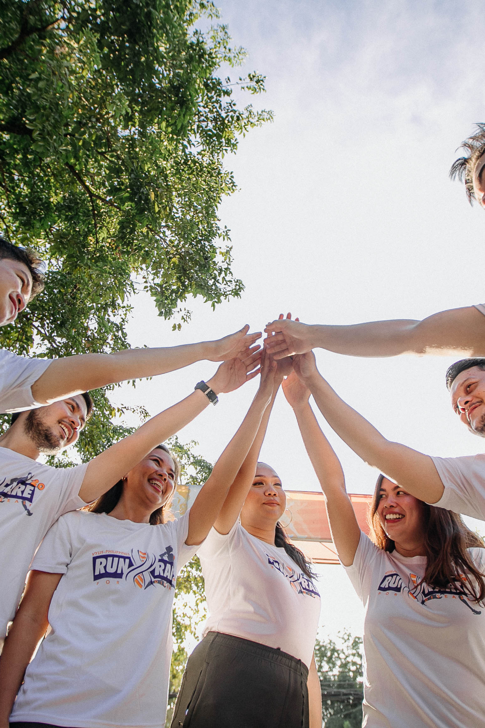 Hands joined in a supportive team huddle, representing unity and collective growth.